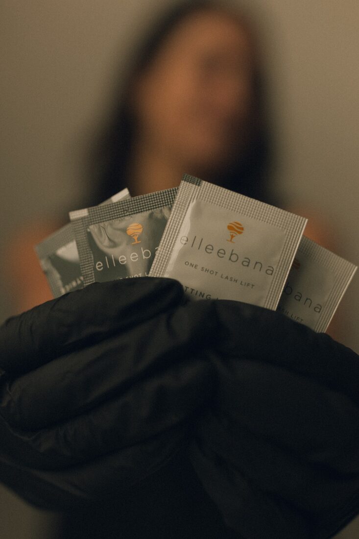 Ellie holding salon-grade Elleebana lash lift products used at Esthetics by Ellie